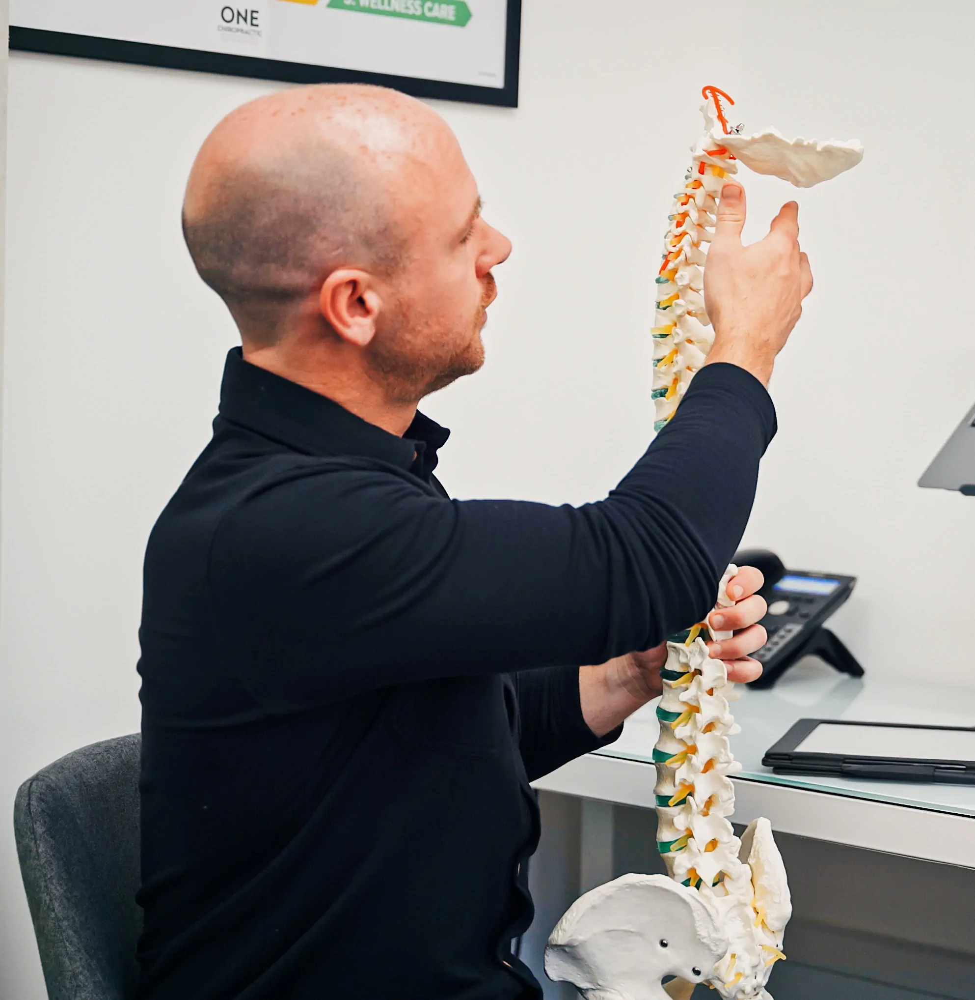 Chiropractor Paul Holmes showing effect of pain on model spine at Edinburgh Leith pain clinic