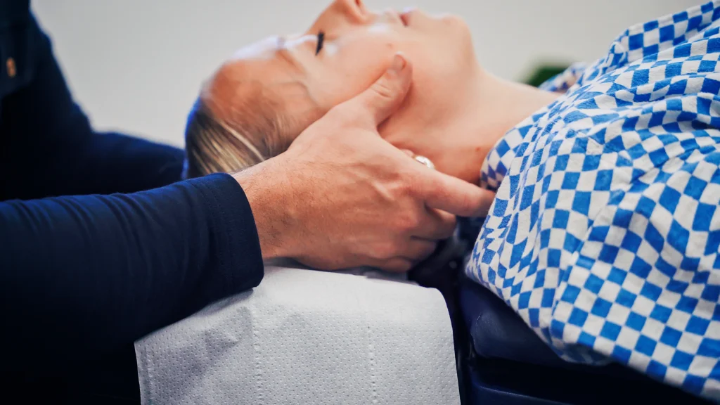 Chiropractor performing neck adjustment on patient in Edinburgh Leith Treatment Clinic