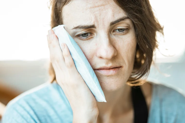 Person holding the side of their face near the jaw and temple, suggesting jaw tension and headache