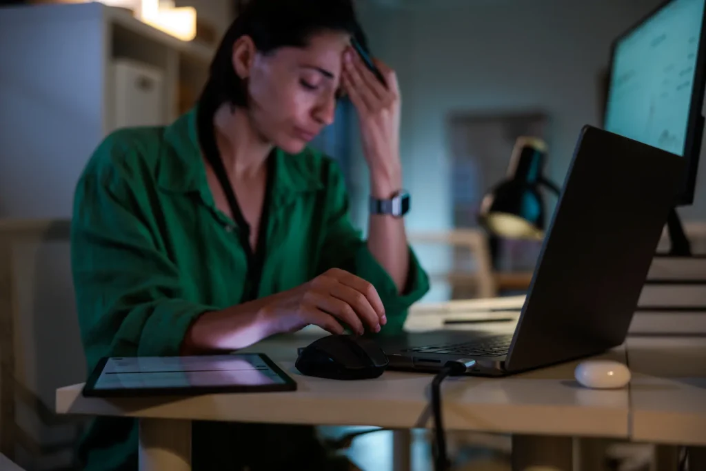 Person with head and neck tension at a desk, a common reason people in Leith see a chiropractor